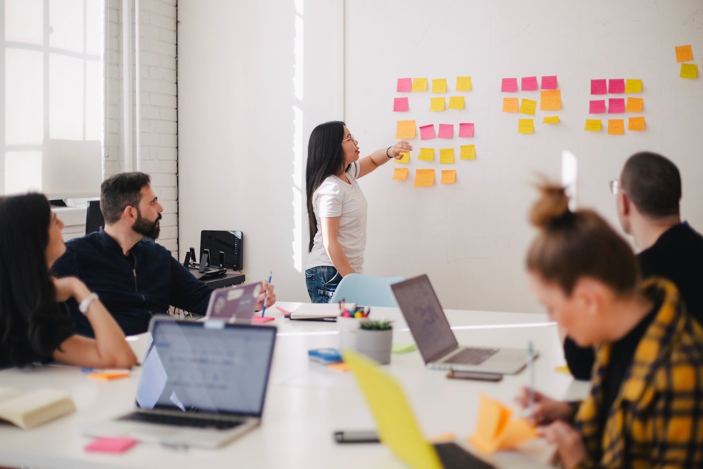 A colleague presenting at a whiteboard covered in sticky notes